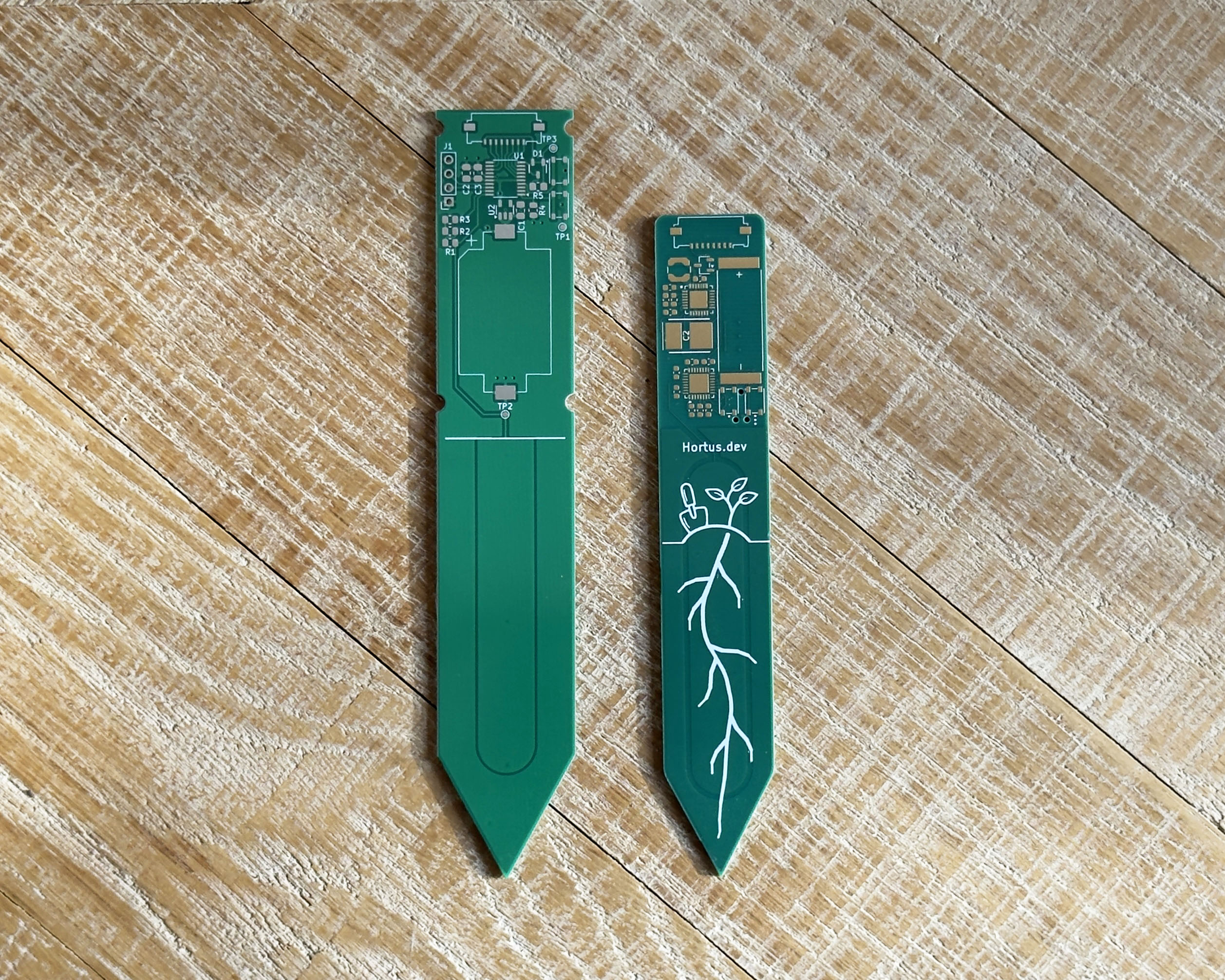 The new board next to the original, showing the narrower form factor and the new logo and roots silkscreen art